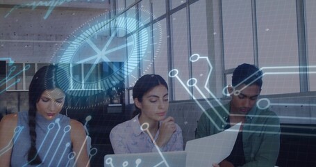 Analyzing team reading laptop and printout in office, wearing dark green shirt, viewing AR overlays