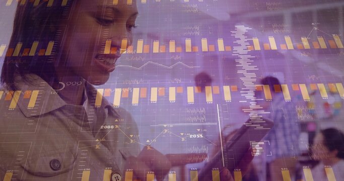 Analyzing woman in light collared jacket tapping tablet in office meeting with bar charts