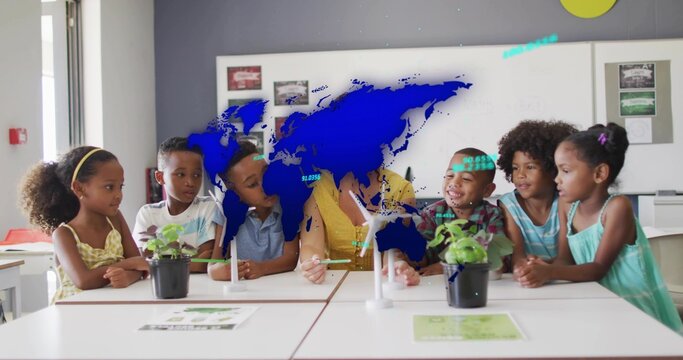 Leading teacher in yellow top leaning forward, handling turbine model at school table, with plants