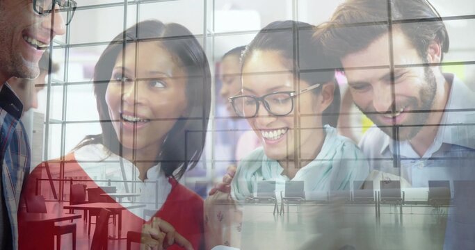 Smiling team leaning over tablet in office with terminal panes, in business clothes, glasses