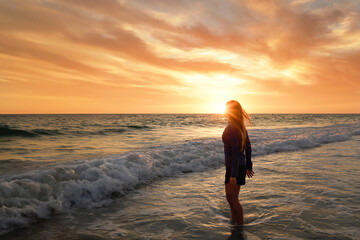 Side view teenage girl standing in water sunset Anna Maria Islan
