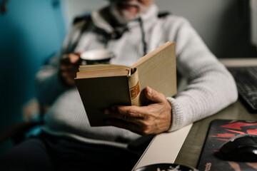 Man reading a book while enjoying a cup of coffee