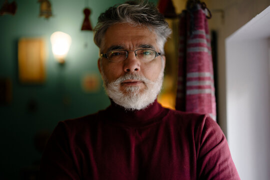 Mature man with gray beard and glasses looking at camera
