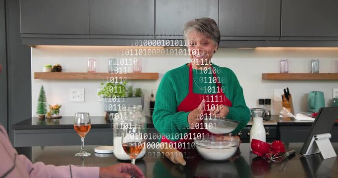 Home cook standing at island sifting flour following tablet recipe, binary code overlaying scene