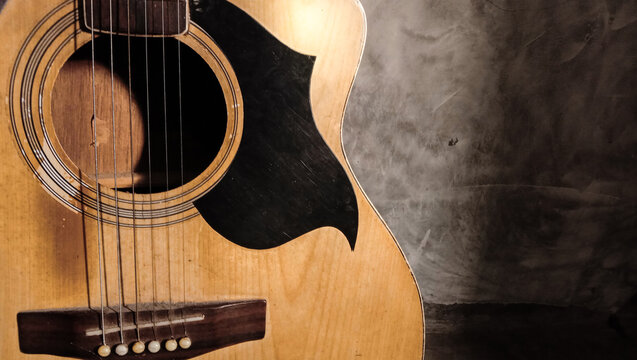 Close up of an acoustic guitar indoors.