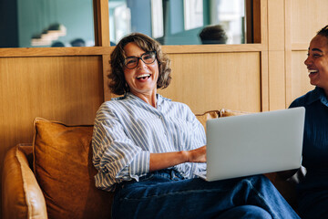 Smiling woman sitting with a laptop during a friendly discussion