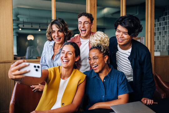 Group of coworkers taking a selfie together at the office