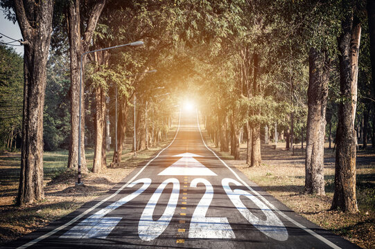 New year 2026 plans with vision concept. number 2026 written on the middle of asphalt road with arrow sign pointing forward and sunlight for start and reach new goals and target for year 2026.