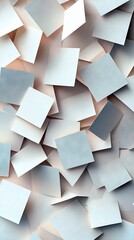 A top-down view of numerous white and light blue square papers scattered and overlapping on a surface, illuminated by soft, warm lighting.