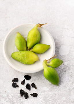 Fresh green Inca cucumber (Cyclanthera pedata) fruits with dried achocha seeds in a minimalist bowl. Ideal for gardeners seeking rare heirloom varieties and high-quality organic achocha seed. 