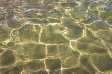 Sun glares on the sandy sea bottom