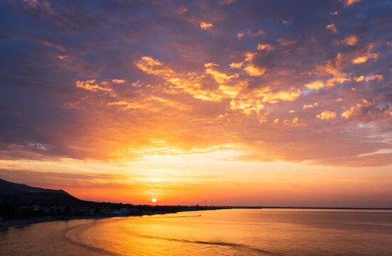 A sunrise over the sea with an amazing bright cloudy sky. Multicoloured sky - Powered by Adobe