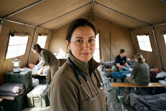 Nurse and doctor in a U.S. disaster relief tent with ongoing work behind them.
