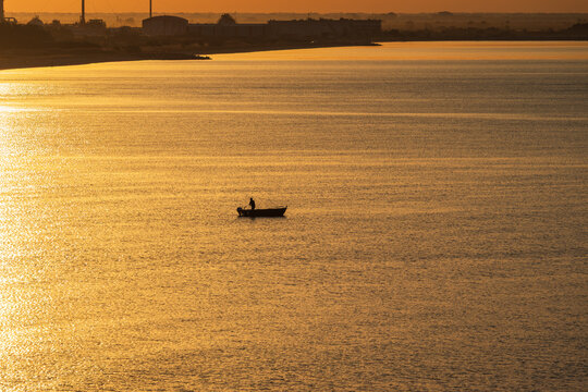 Fisherman on a boat in the sea at a sunrise - Powered by Adobe