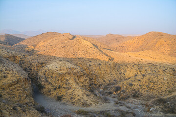 A canyon in the desert. Bare mountains and a canyon. Beautiful nature like on planet Mars. The rocky walls of the canyon are high. Mountain landscape