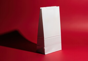 Minimalist white paper bag standing tall against a vibrant red background