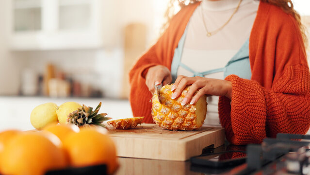Hands, cutting and woman in kitchen, pineapple and nutrition with healthy snack. Home, knife and person with sharp utensil, wellness and diet meal with organic ingredients, chopping board and fruit - Powered by Adobe