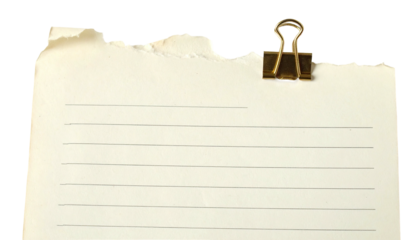 Torn, lined paper held by a brass clip against a black backdrop