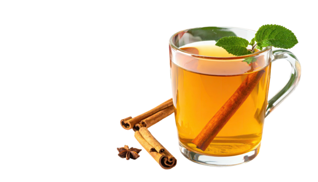 A glass mug filled with tea, cinnamon sticks, and mint leaves on a black background