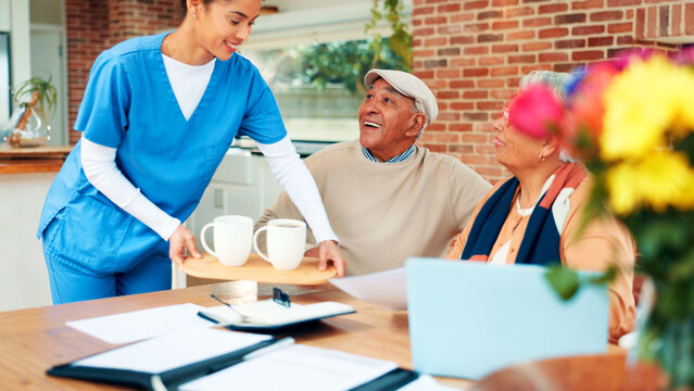 Happy, old couple and caregiver with coffee, homecare and financial planning with paperwork and tech. Assisted living, elderly man or senior woman with document, laugh and nurse with tea for wellness - Powered by Adobe