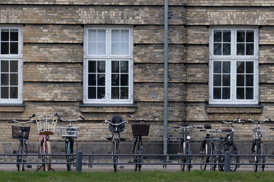 Copenhagen urban architecture brick facade with window detail and bicycles arranged in alignment to reinforce structure and clarity within an exterior view crafted for visual communication