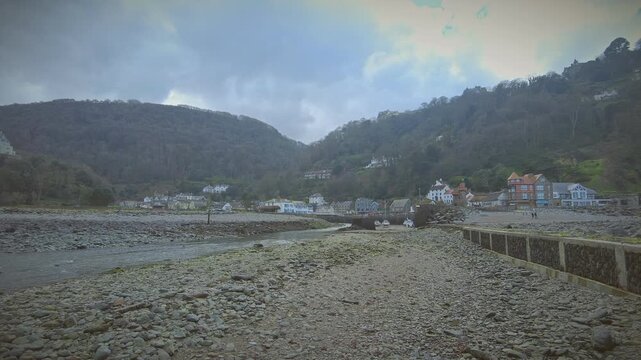 Static shot of the Lyn River flowing into the Bristol Channel at Lynmouth in Exmoor, Devon on a cloudy and hazy day.