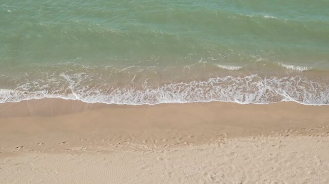 sea surf on a sandy beach, top view, slow motion
