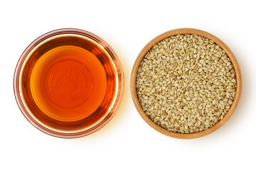 Sesame oil in glass bowl and sesame seeds in wooden bowl on white background
