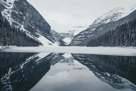 Beautiful serene winter landscape with snowy mountains and calm lake reflection, peaceful scenery, generative ai