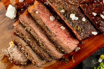 Perfectly Cooked and Sliced Juicy Steak with Sea Salt on a Wooden Board