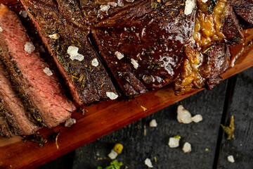 Grilled and Seasoned Juicy Sliced Steak with Flaky Salt on a Wooden Board