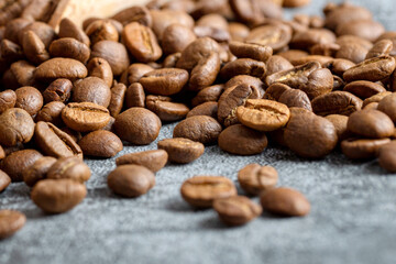Close-up of Rich Brown Roasted Coffee Beans Scattered on a Grey Surface