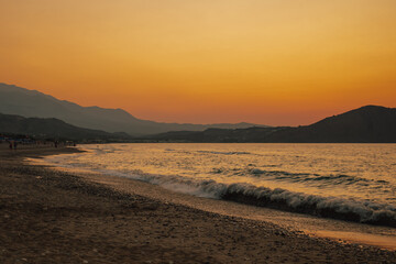 Vibrant orange and pink colors of the sun setting over the tranquil sea
