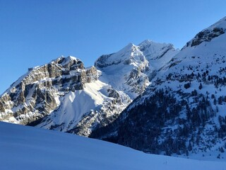 Breathtaking Swiss mountain landscape in winter with clear morning light, deep fresh snow under a blue sky, Kandersteg, Sunnbüel, Bernese Oberland, Switzerland