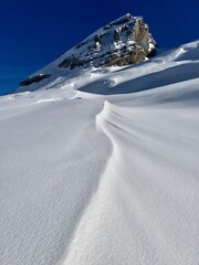 Breathtaking Swiss mountain landscape in winter with clear morning light, deep fresh snow under a blue sky, Kandersteg, Sunnbüel, Bernese Oberland, Switzerland