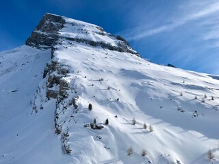 Breathtaking Swiss mountain landscape in winter with clear morning light, deep fresh snow under a blue sky, Kandersteg, Sunnbüel, Bernese Oberland, Switzerland
