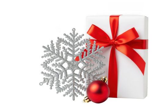 A white gift box with a red ribbon and bow, next to a silver snowflake and a red ornament, isolated on transparent background