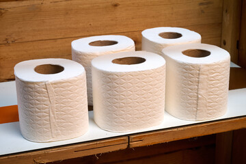 toilet paper rolls on a wooden shelf