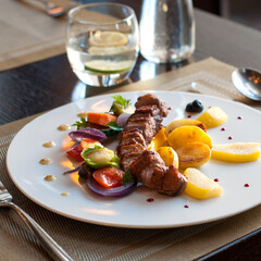 Grilled pork loin with vegetables on a plate in restaurant