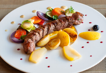 Grilled pork loin with vegetables on a plate in restaurant