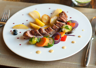 Grilled pork loin with vegetables on a plate in restaurant