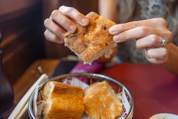 Woman Breaking Fresh Bread at Table