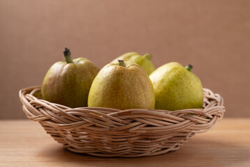 Fresh pear in basket on wooden background