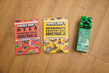 Naklejka premium Minecraft books and Creeper figure on a wooden surface, perfect for gaming fans