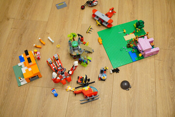 Obraz premium Colorful toy building blocks scattered on a wooden floor, overhead shot