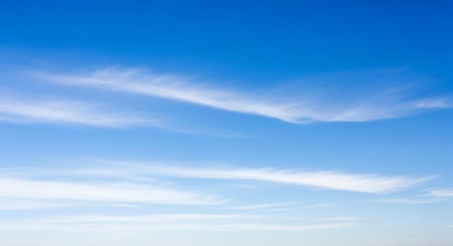 Vast blue sky with delicate, wispy white cirrus clouds stretching horizontally across the wide horizon on a clear day - Powered by Adobe
