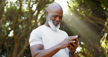 Mature black man, phone and fitness at park, smile and scroll with application, notification and outdoor. African person, runner and happy with smartphone, timer and stopwatch for exercise in nature