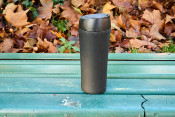Outdoor. Thermos of coffee on a public bench