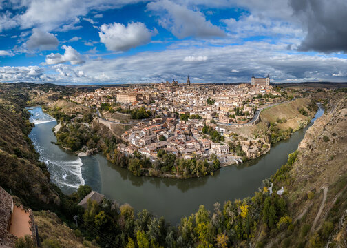 Aerial view of the ancient city encircled by the Tagus River, showcasing a tapestry of terracotta roofs and historic architecture, Toledo, Castile-La Mancha, Spain.
