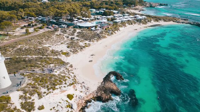 Cinematic aerial footage panning away and upwards from Pinky Beach and Bathurst Lighthouse on Rottnest Island in Perth, Western Australia.